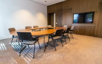 Spacious furnished conference room at Weena 290, Rotterdam Central Station, ideal for office space rental with a sleek table and chairs.
