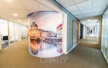 Bright office hallway at Weena 290, Rotterdam Central Station, featuring scenic wall art. Ideal spot for office space rental with fully furnished rooms and modern decor.