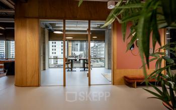 Modern office space with glass walls and city views at Hofplein 19, Rotterdam Central Station. Ideal for office space rental with contemporary design and natural light.