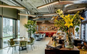 Modern office interior at Hofplein 19, Rotterdam Central Station featuring stylish furnishings, ambient lighting, and vibrant decor ideal for office space rental.