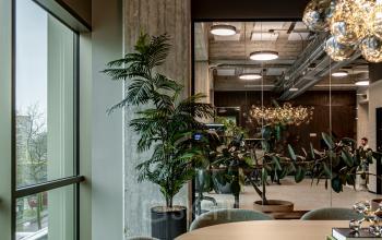 Office space in Rotterdam Central Station at Hofplein 19 featuring a stylish conference room with a round table, modern chairs, and large windows offering city views. Ideal for office space rental.