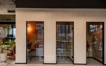 Modern office interior at Hofplein 19 in Rotterdam Central Station, featuring private workspaces with glass partitions, contemporary furnishings, and stylish decor ideal for office space rental.