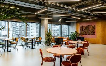 Stylish furnished office space with modern decor and large windows overlooking Rotterdam Central Station. Ideal for businesses seeking office space rental that encourages creativity and collaboration in a vibrant setting.