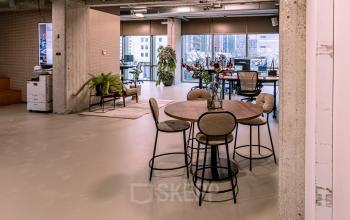 Spacious and modern open floor plan at Hofplein 19, featuring sleek workspaces with city views and contemporary furnishings, ideal for office space rental in Rotterdam Central Station area.