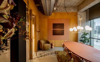 Stylish conference room at Hofplein 19, featuring a large table with modern lighting and decor, ideal for office space rental in Rotterdam Central Station.