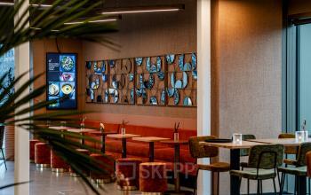 Stylish meeting area in a Rotterdam Central Station building with modern seating and decorative wall accents. Ideal for office space rental, featuring warm tones and contemporary design for productive discussions.