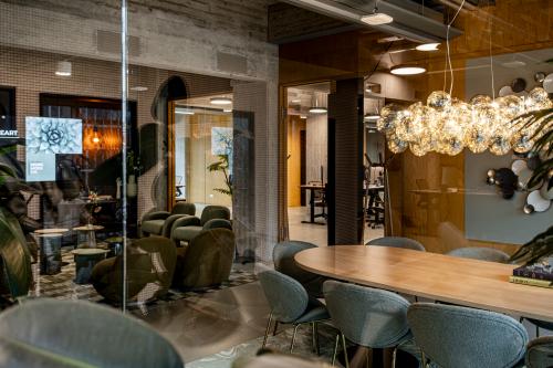 Modern workspace at Hofplein 19, Rotterdam Central Station featuring stylish seating, a chic light fixture, and a collaborative atmosphere, ideal for office space rental.