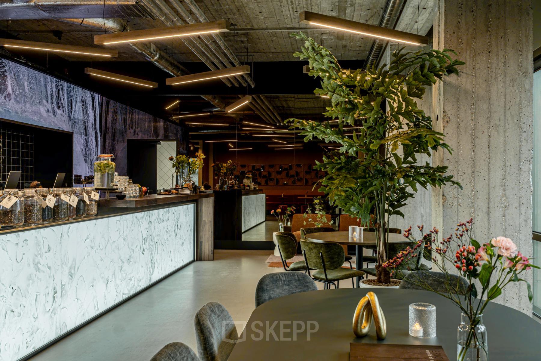 Modern office space at Hofplein 19, Rotterdam Central Station, featuring contemporary decor with sleek furniture and stylish lighting, ideal for open workspace and collaboration. Perfect for office space rental.