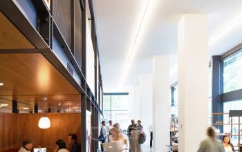 Interior view of office space rental at Hofplein 20, Rotterdam Central Station, featuring people working in modern booths and open work areas.