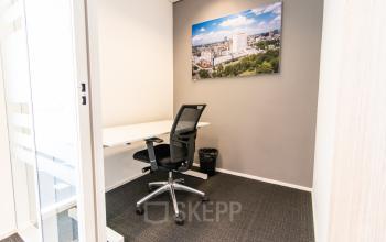 Modern, furnished office space with a desk and chair at Weena-Zuid 130, Rotterdam Central Station, available for rent.