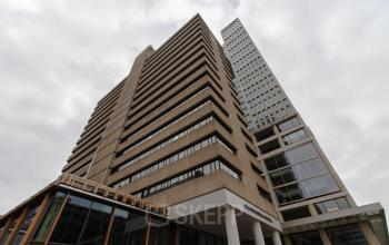 Exterior view of a large office building at Weena 750, Rotterdam Central Station, showcasing modern architecture, ideal for office space rental.