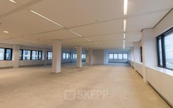 Spacious office space for rental located at Weena 750, Rotterdam Central Station, featuring large windows and ample lighting.