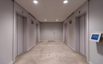 Hallway with elevator doors at Weena 750, Rotterdam Central Station, illustrating office space rental options.
