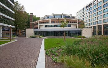 Exterior view of office building at Kruisplein 15-25, Rotterdam Central Station, Rotterdam, showcasing modern architecture and surrounding green spaces, available for office space rental.