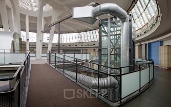 Interior view of modern office space at Kruisplein 15-25, Rotterdam Central Station, featuring an industrial design with glass walls and metallic ducts.