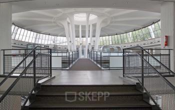 Interior of an office space at Kruisplein 15-25, Rotterdam Central Station, with modern architecture featuring large windows and open walkways.