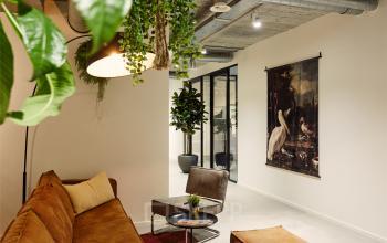 Cozy office lounge area with modern furniture and indoor plants at Westblaak 90 in Rotterdam Center, suitable for office space rental.