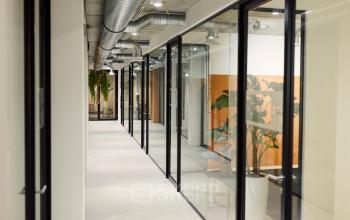 Modern office space rental at Westblaak 90, Rotterdam Center featuring sleek glass walls, industrial ceilings, and minimalistic decor.