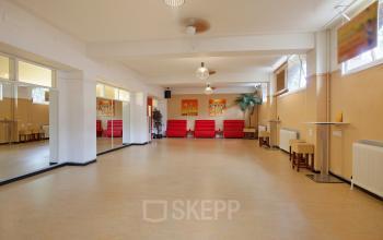 Spacious and well-lit office space rental at Schiekade 830, Rotterdam Center, with red sofas and tasteful décor.