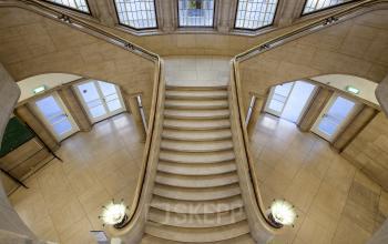 Elegant stairway with large windows at Schiekade 830 office space rental, in Rotterdam Center, showcasing architectural details.