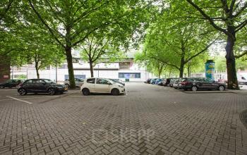 Parking area surrounded by trees at Schiekade 830, Rotterdam Center. It offers convenient access for office space rental, providing a peaceful setting within the city.