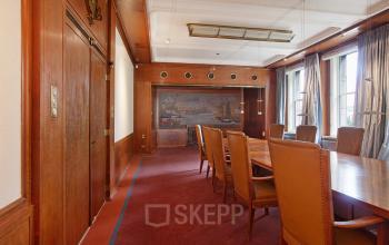 Elegant office space rental at Schiekade 830, Rotterdam Center, with a large wooden table and leather chairs for team meetings.
