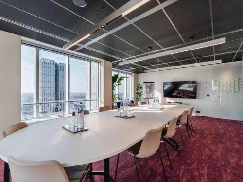 Conference room at Weena 690, Rotterdam Center, with large table, chairs, and city view. Ideal office space rental for meetings and business gatherings.