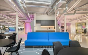 Bright office space rental at Vasteland 42-110, Rotterdam, with modern blue sofa and striking interior design accents.