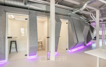 Modern office space rental at Vasteland 42-110, Rotterdam, with stylish furnishings and vibrant purple accent lighting.