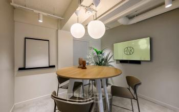 Modern conference room at Vasteland 42-110 in Rotterdam Center with a round table, chairs, and a wall-mounted screen, suitable for office space rental.