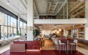 Modern interior office space located at Vasteland 42-110 in Rotterdam Center with open seating, high ceilings, and large windows. Office space rental in a vibrant environment.