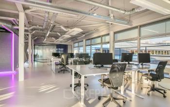 Modern office space rental with vibrant lighting and sleek desks at Vasteland 42-110, Rotterdam.