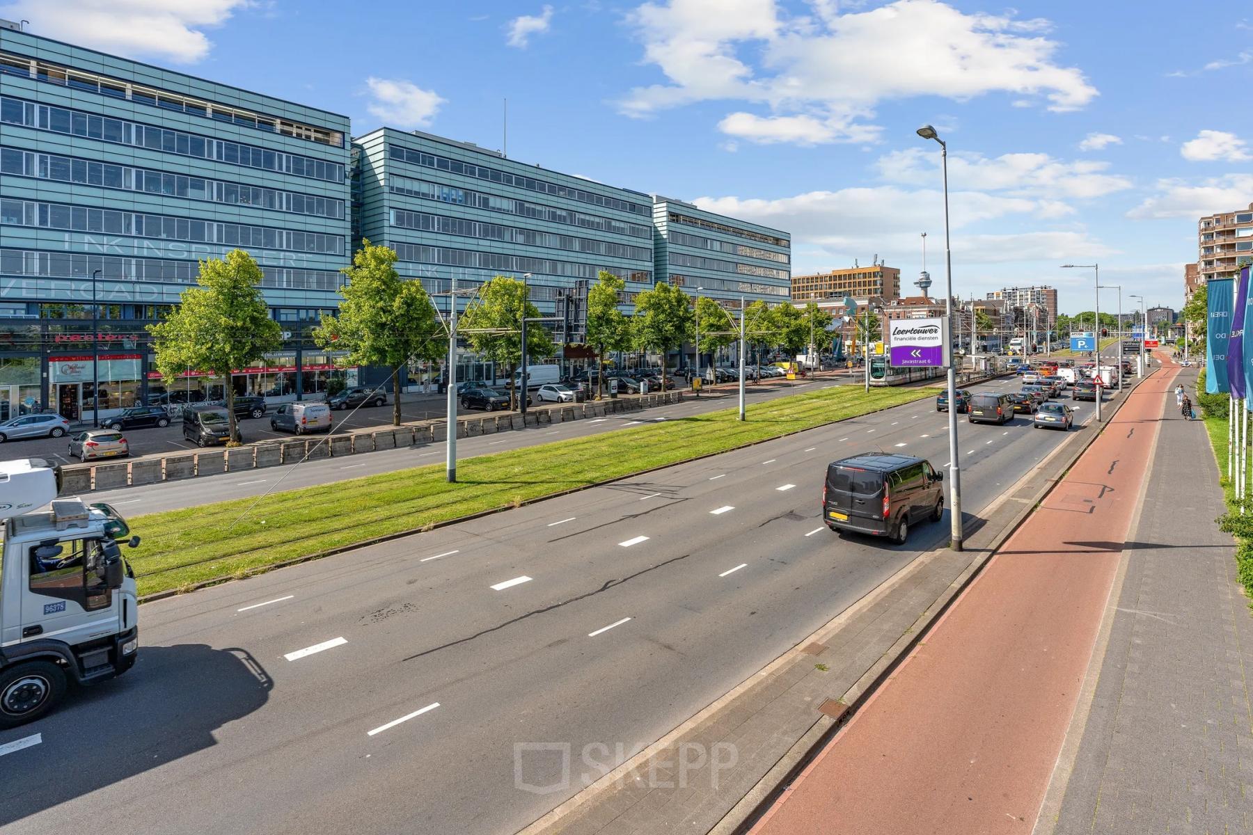 Street view of Vasteland 42-110 in Rotterdam Center showing a modern office building with cars passing by, ideal for those looking to rent office space.