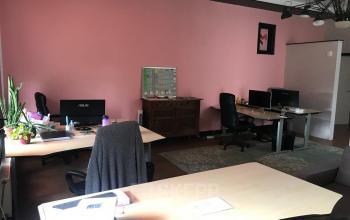 Interior view of office space rental at Schiekade 105 in Rotterdam Center, with several desks, chairs, and office equipment.