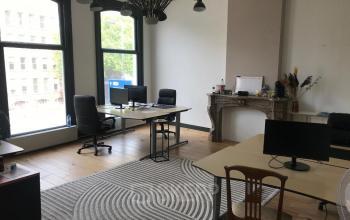 Bright office space with large windows and multiple desks available for rent at Schiekade 105, Rotterdam Center.