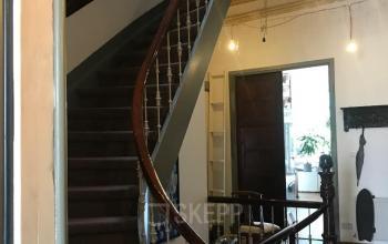 Interior view of office at Schiekade 105, Rotterdam Center showing a wooden staircase and hallway with soft lighting.