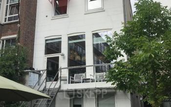 Exterior view of office building at Schiekade 105, Rotterdam Center with outdoor seating area and staircase.