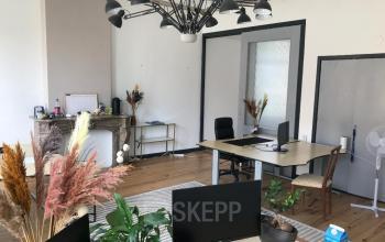 Spacious office space rental at Schiekade 105, Rotterdam Center, featuring modern furniture, wooden flooring, and decorative plants.