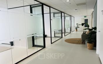 Modern office space at Kruisplein 480 in Rotterdam Center featuring glass-walled rooms and comfortable furnishings, ideal for office space rental.