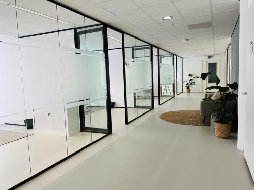 Modern office space at Kruisplein 480 in Rotterdam Center featuring glass-walled rooms and comfortable furnishings, ideal for office space rental.