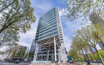 A modern high-rise office building located at Blaak 555 in Rotterdam Center, ideal for those seeking office space rental in the city.