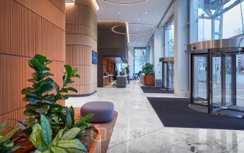 Spacious reception area at Blaak 555, Rotterdam Center, featuring modern decor and plant accents. Ideal for businesses seeking office space rental.
