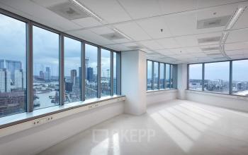 Bright, unfurnished office space at Blaak 555 in Rotterdam Center, featuring large windows with city views, ideal for office space rental.