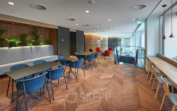 Modern office lounge area at Blaak 555 in Rotterdam Center with stylish decor and ample seating, ideal for office space rental.