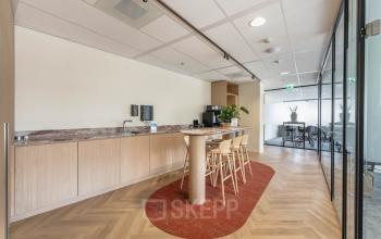 Bright office space at Blaak 555, Rotterdam Center, featuring an inviting lounge area with modern furniture and sleek design, ideal for office space rental.