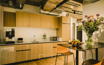 Modern furnished pantry at Coolsingel 65, Rotterdam Center, featuring sleek cabinets and a coffee machine, available for office space rental.