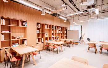 Bright, furnished office space with wooden tables and shelves located at Hoogstraat 185, Rotterdam Center, ideal for office space rental.