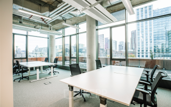Spacious office to rent at Hoogstraat 185, Rotterdam Center, featuring large windows, multiple desks, and ergonomic chairs. Ideal office space rental with city views.