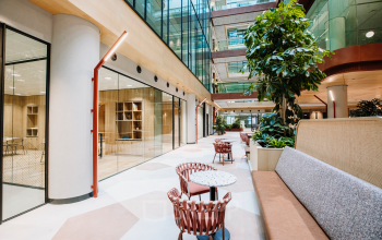 Bright office space to rent in Rotterdam Center, featuring modern interior with seating and glass walls, perfect for collaborative work environments.