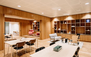A modern office space to rent on Hoogstraat 185, Rotterdam Center, featuring sleek wooden decor with tables and chairs, ideal for office space rental.